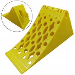 A chock under the wheel of a car trailer secures the large wheel