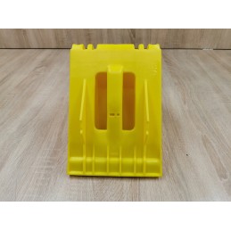 A chock under the wheel of a car trailer secures the large wheel