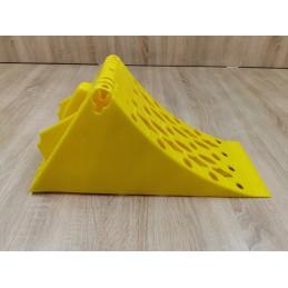 A chock under the wheel of a car trailer secures the large wheel