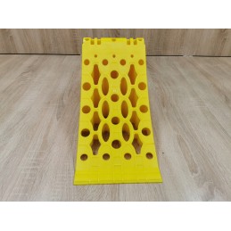 A chock under the wheel of a car trailer secures the large wheel