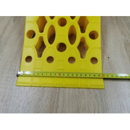 A chock under the wheel of a car trailer secures the large wheel