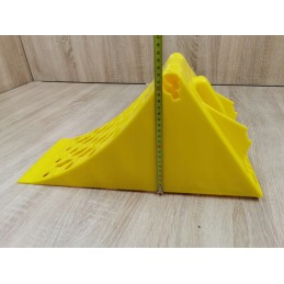 A chock under the wheel of a car trailer secures the large wheel